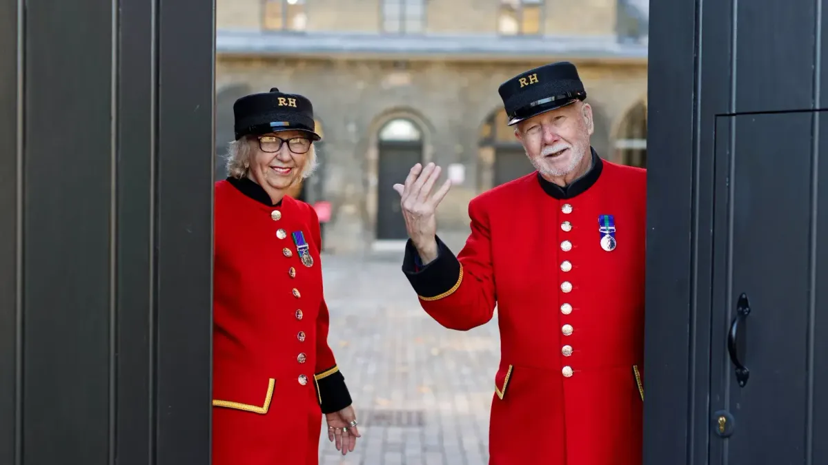 Two Chelsea Pensioners welcoming guests inside.
